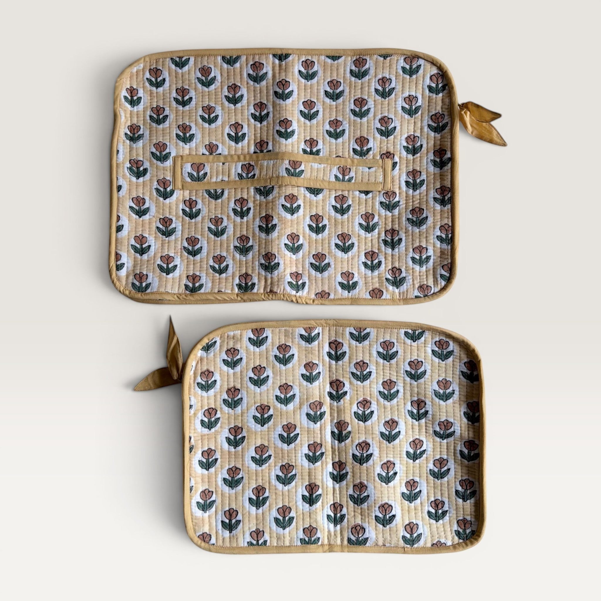The Block & Bloom quilted laptop sleeve in yellow with rust tulip print, featuring a back strap and YKK zipper.