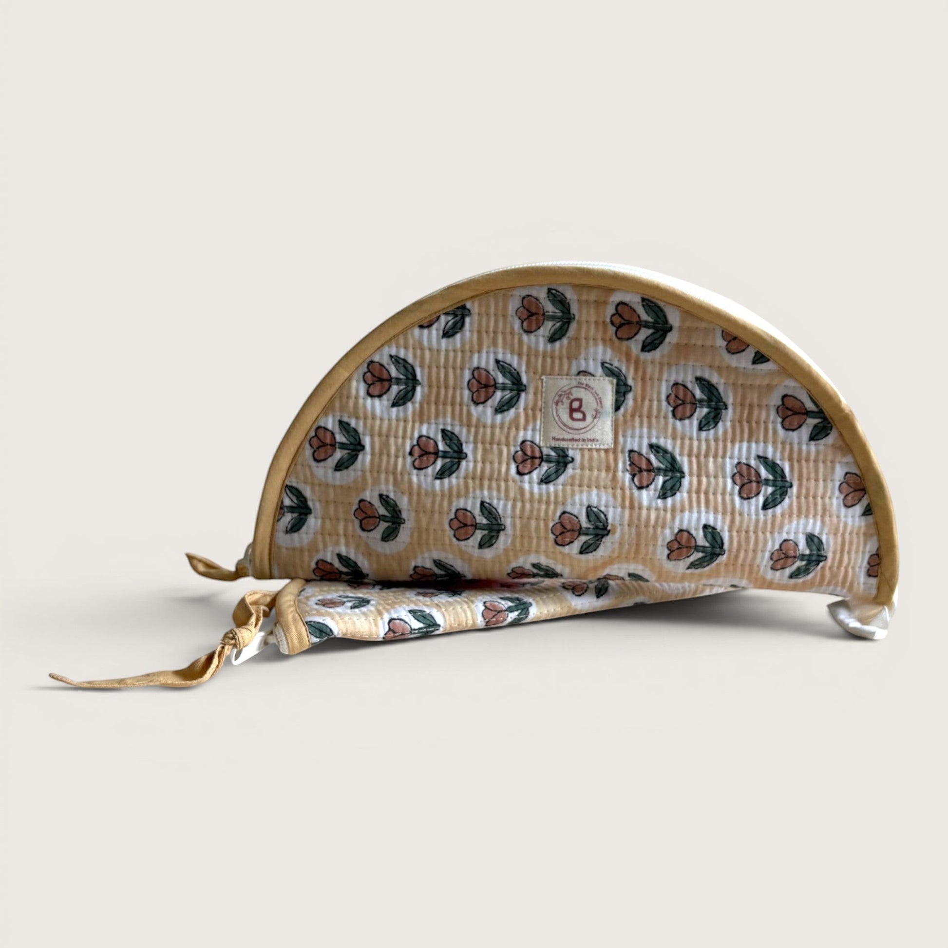 The Block & Bloom quilted makeup brush pouch in golden yellow with a rust tulip print and white oval frames.