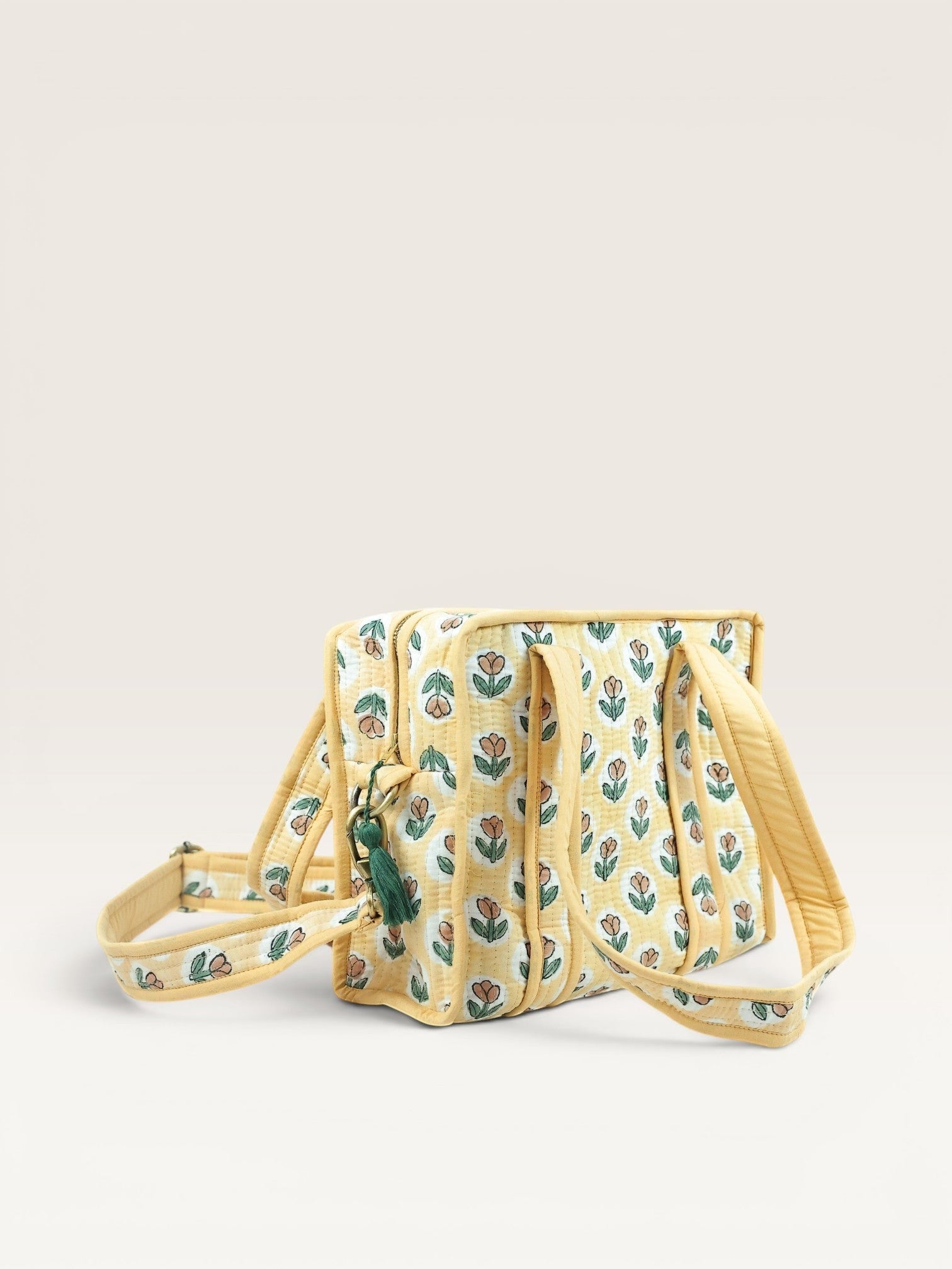 The Block & Bloom quilted mini tote in yellow with rust tulip block prints, padded handles, and brass hardware.