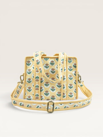 The Block & Bloom quilted mini tote in golden yellow with rust tulip block print, padded handles, and crossbody strap.