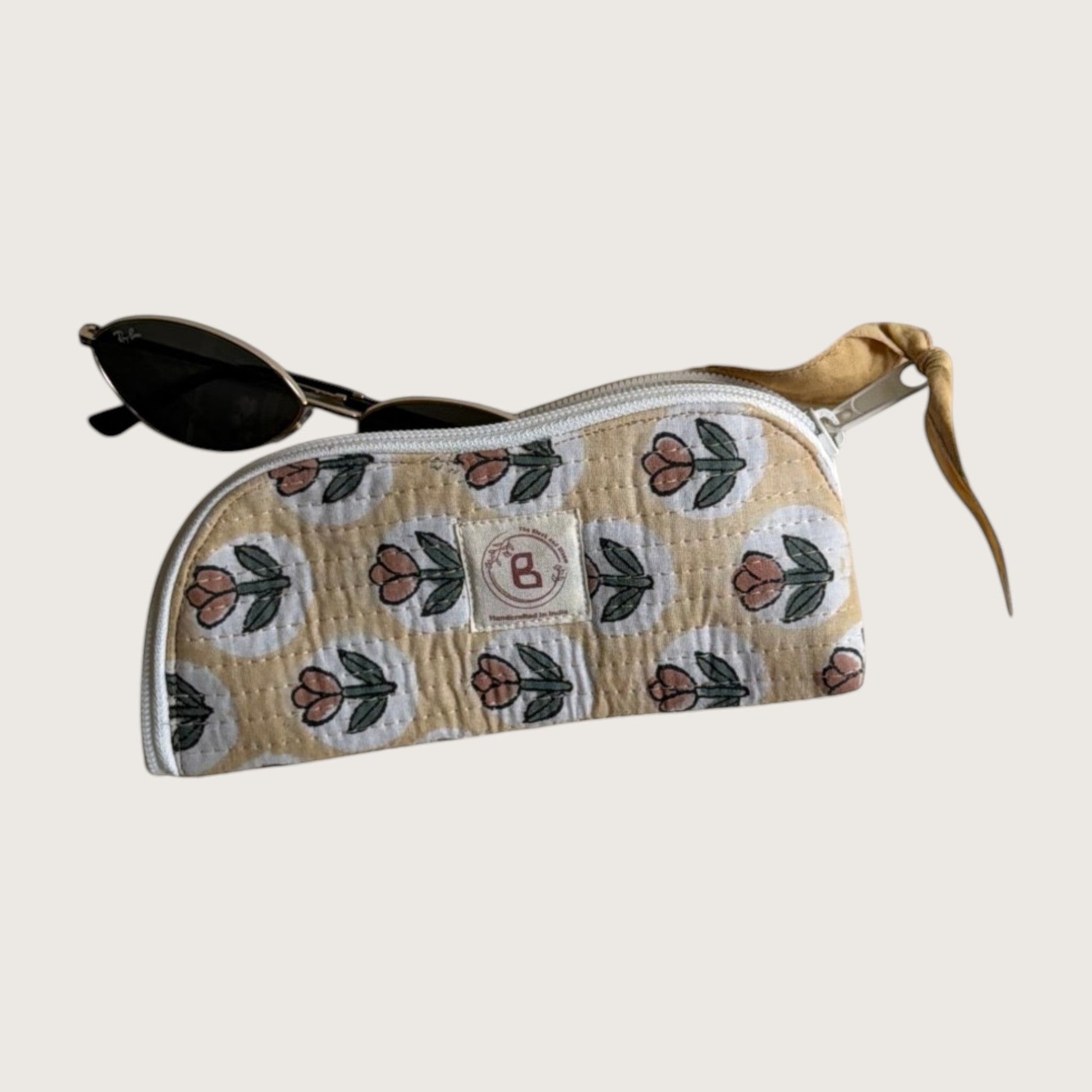 The Block & Bloom quilted cotton sunglasses pouch in golden yellow with a rust tulip print and white zipper closure.