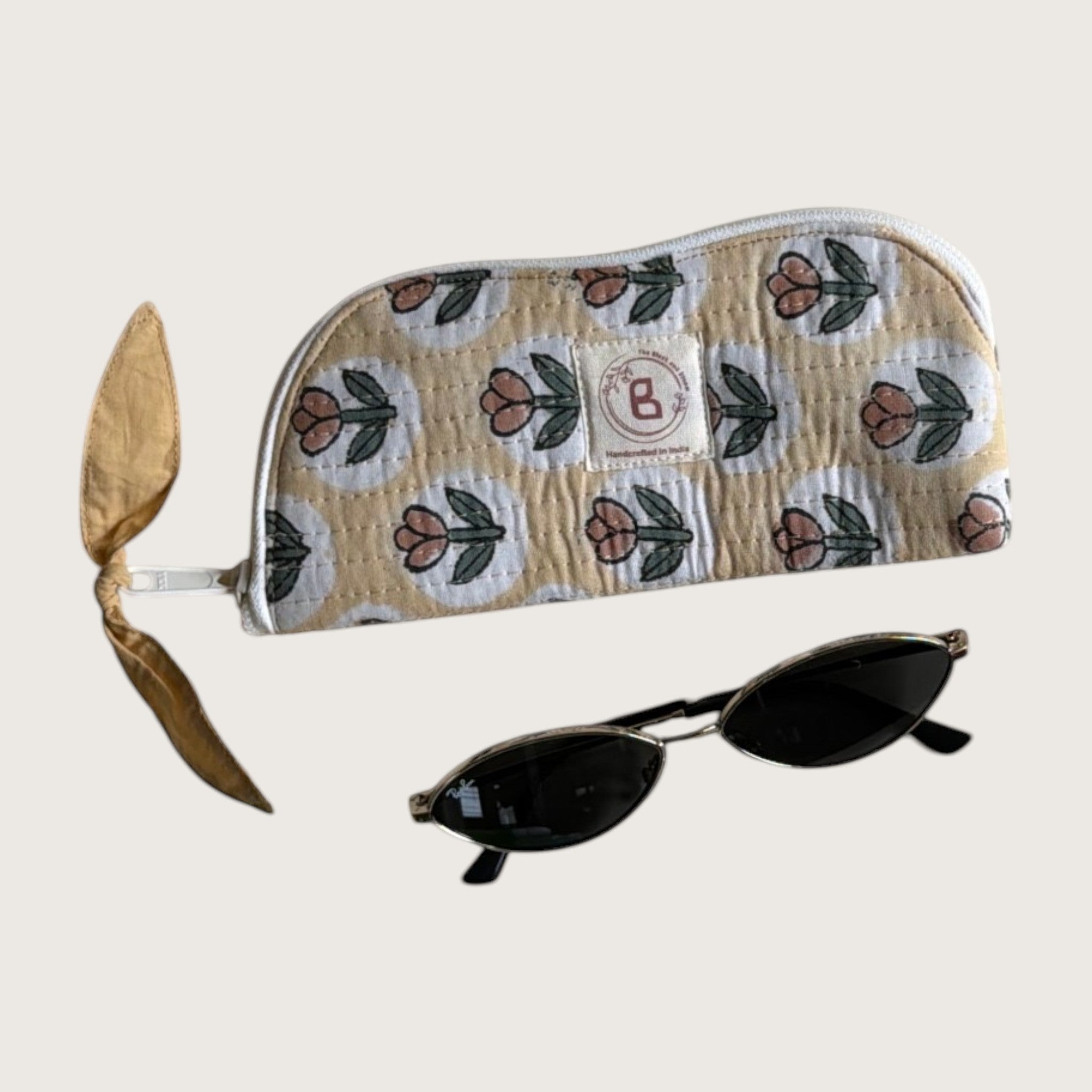 The Block & Bloom quilted cotton sunglasses pouch in golden yellow with a rust tulip print and a side zipper pull.