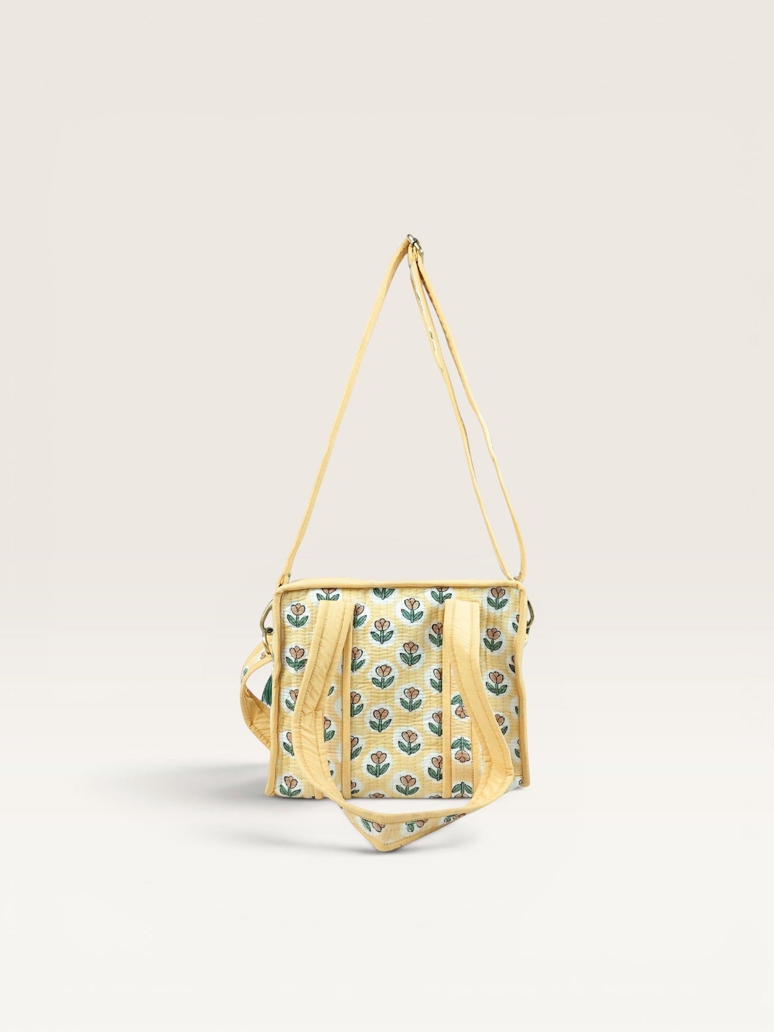 The Block & Bloom quilted mini tote in yellow with rust tulip block print, featuring padded handles and crossbody strap.