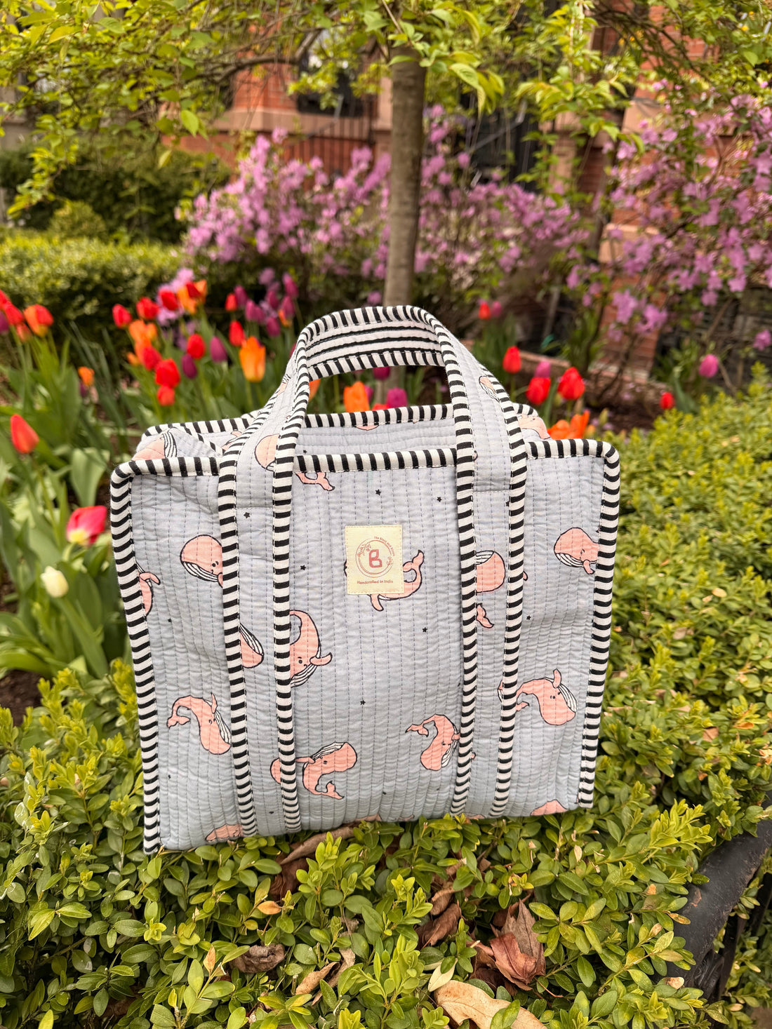 The Block & Bloom quilted mini tote in grey with pink whale print and black-and-white striped trim.
