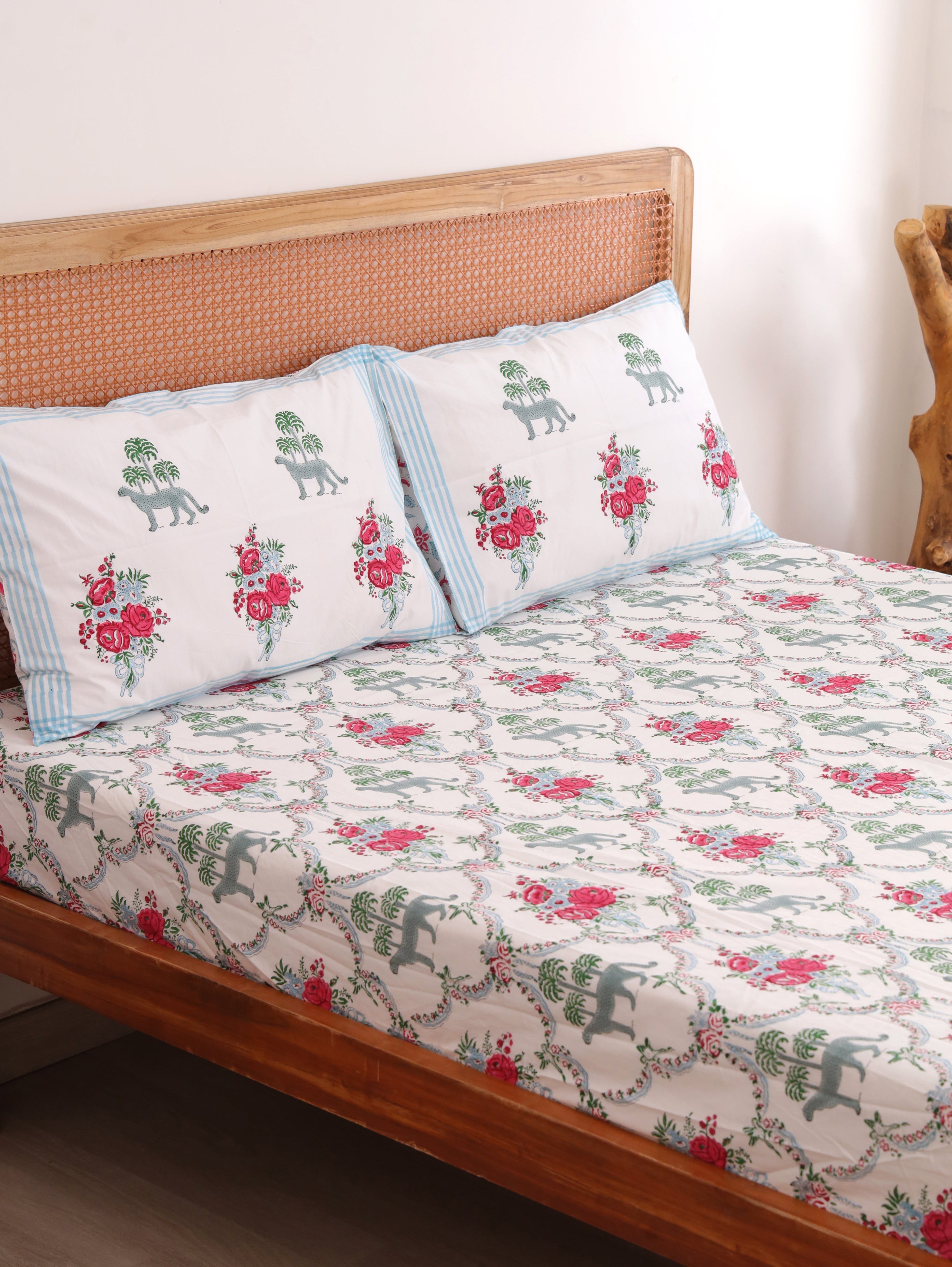 The Block & Bloom Royal Bagh cotton fitted sheet and pillowcases with cheetah, palm, and pink rose block print.