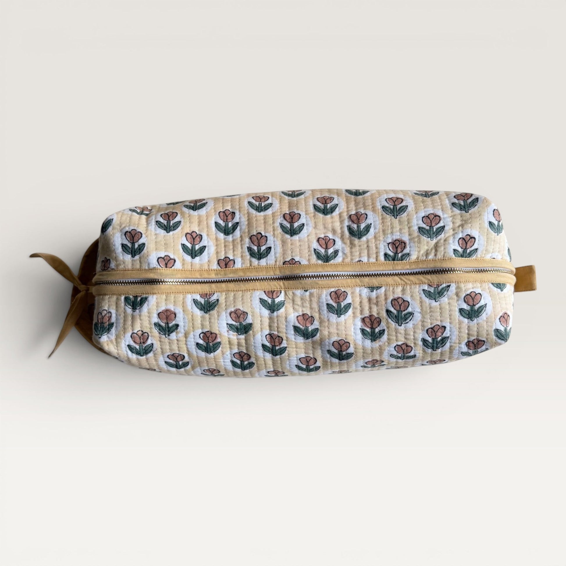 The Block & Bloom quilted hair tool organizer in golden yellow with a rust tulip block-print pattern and YKK zipper.