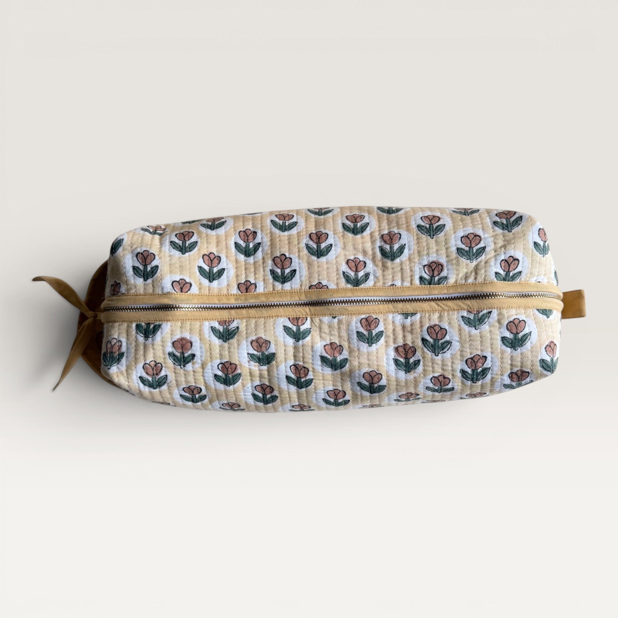 The Block & Bloom quilted hair tool organizer in golden yellow with a rust tulip block-print pattern and YKK zipper.
