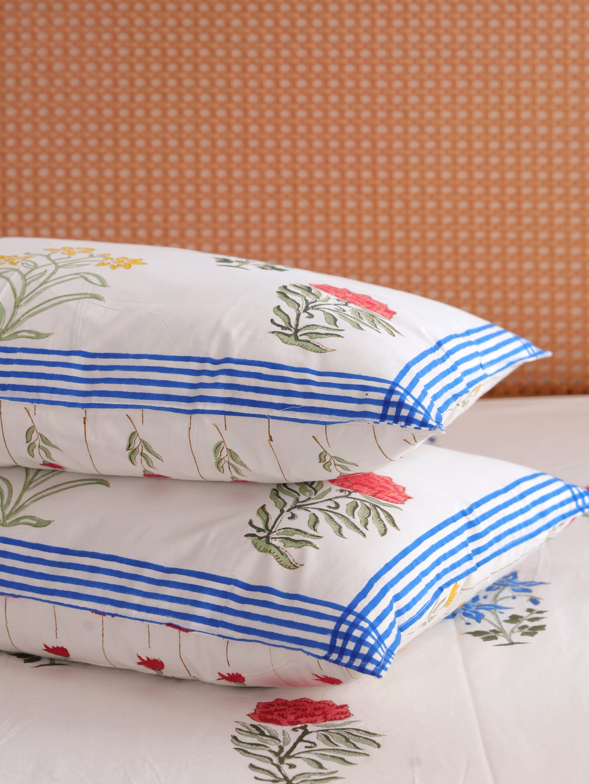 The Block & Bloom Wildflower Bagh cotton pillowcases with floral print and blue gingham borders on a matching sheet.