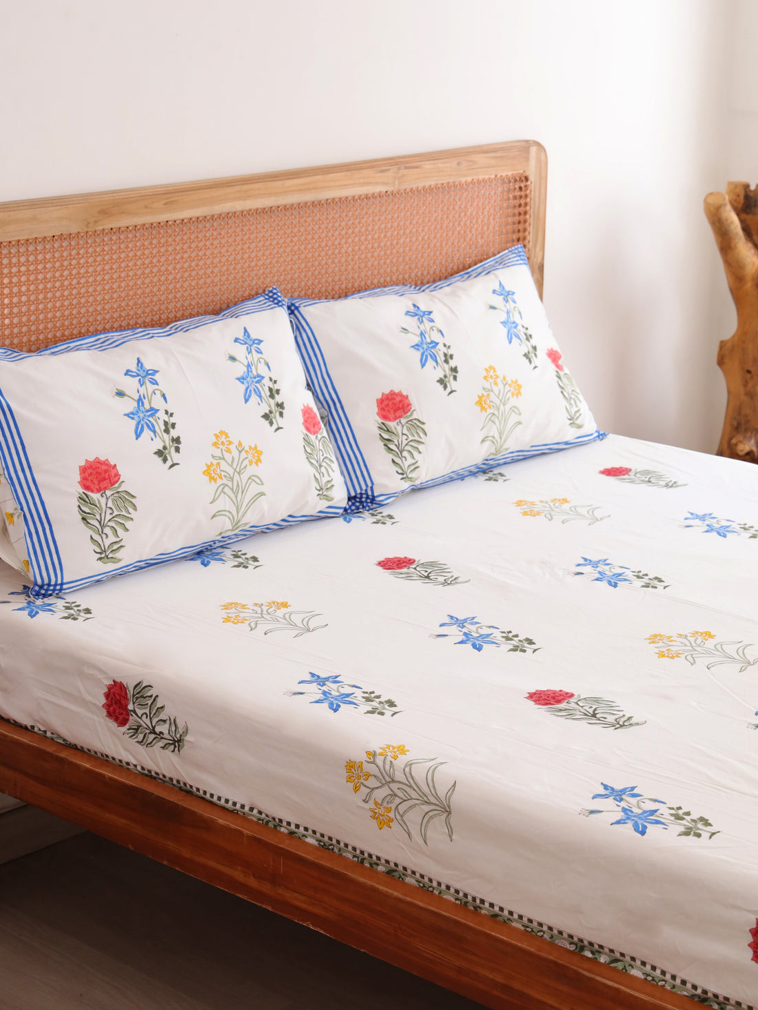 The Block & Bloom Wildflower Bagh cotton fitted sheet and pillowcases with blue, pink, and yellow floral block prints.