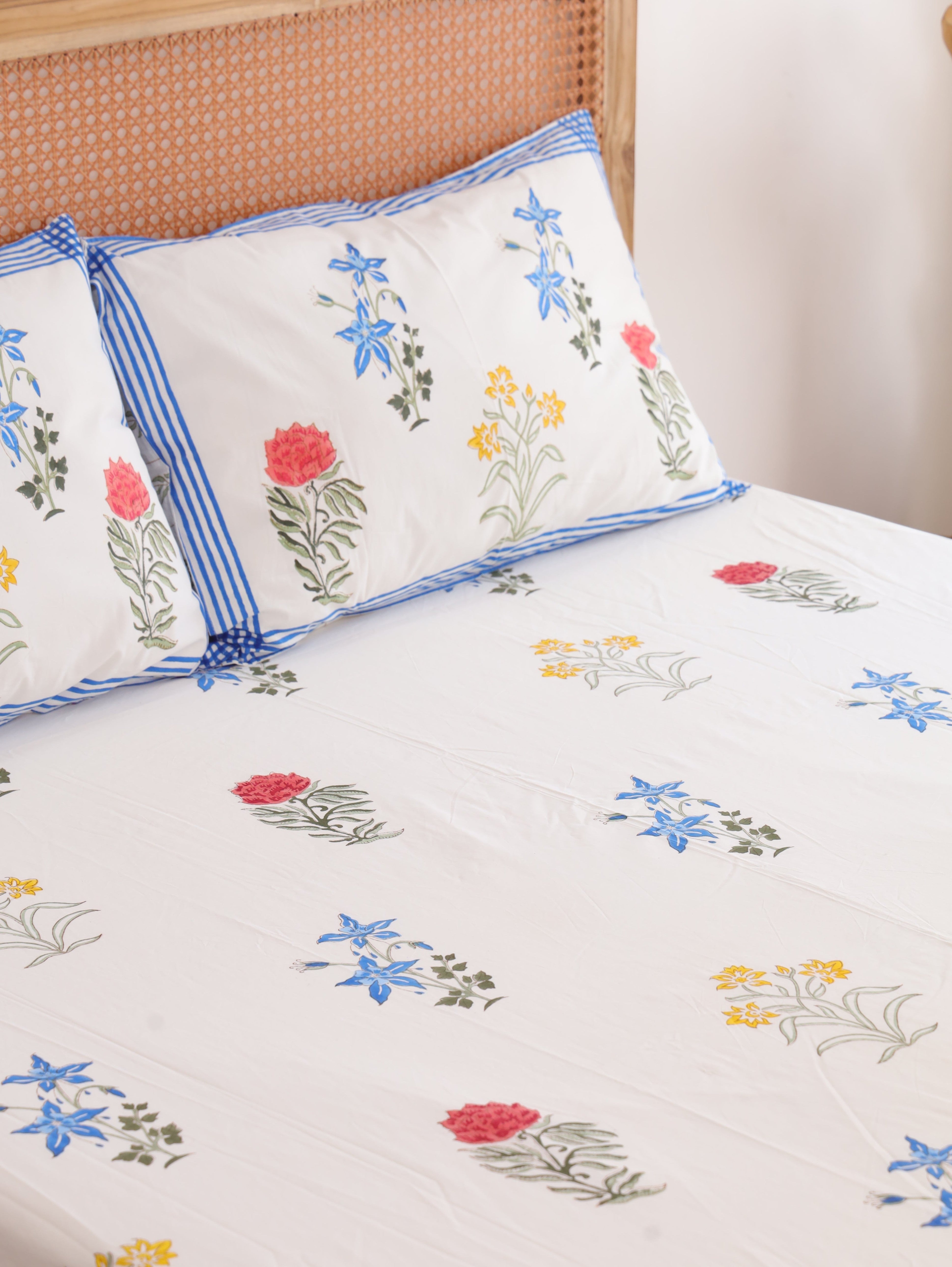 The Block & Bloom Wildflower Bagh cotton fitted sheet and pillowcases with blue, pink, and yellow floral block print.